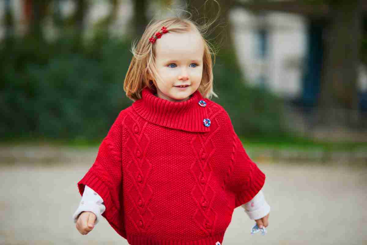Bambina che corre con una mantellina rossa