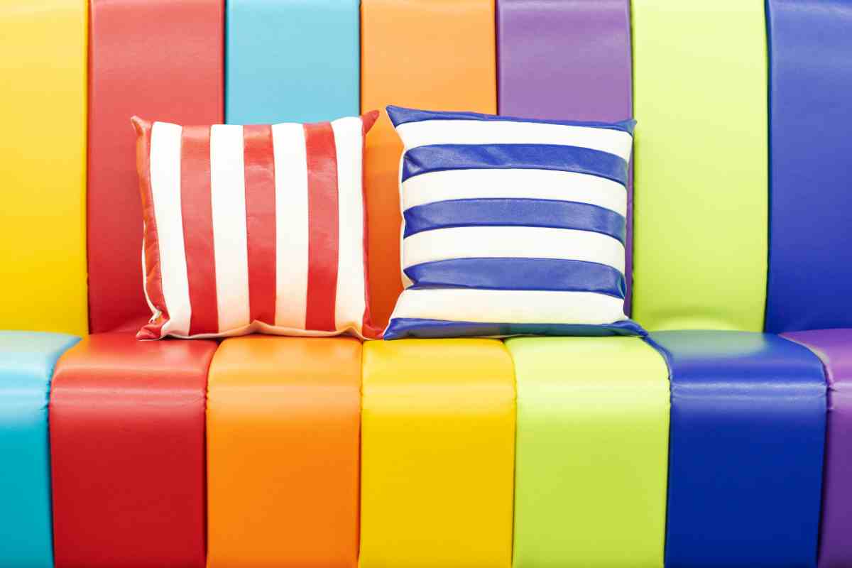 divano a strisce colorate in pelle lucido e cuscini a righie