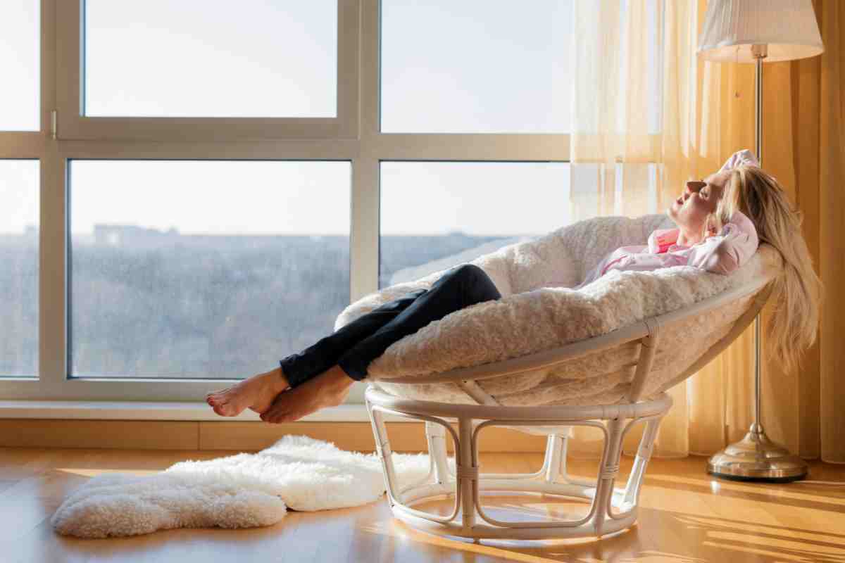 donna comodamente seduta in poltrona nell'angolo relax in casa