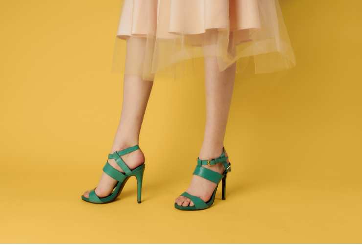 gambe con scarpe verdi e vestito beige