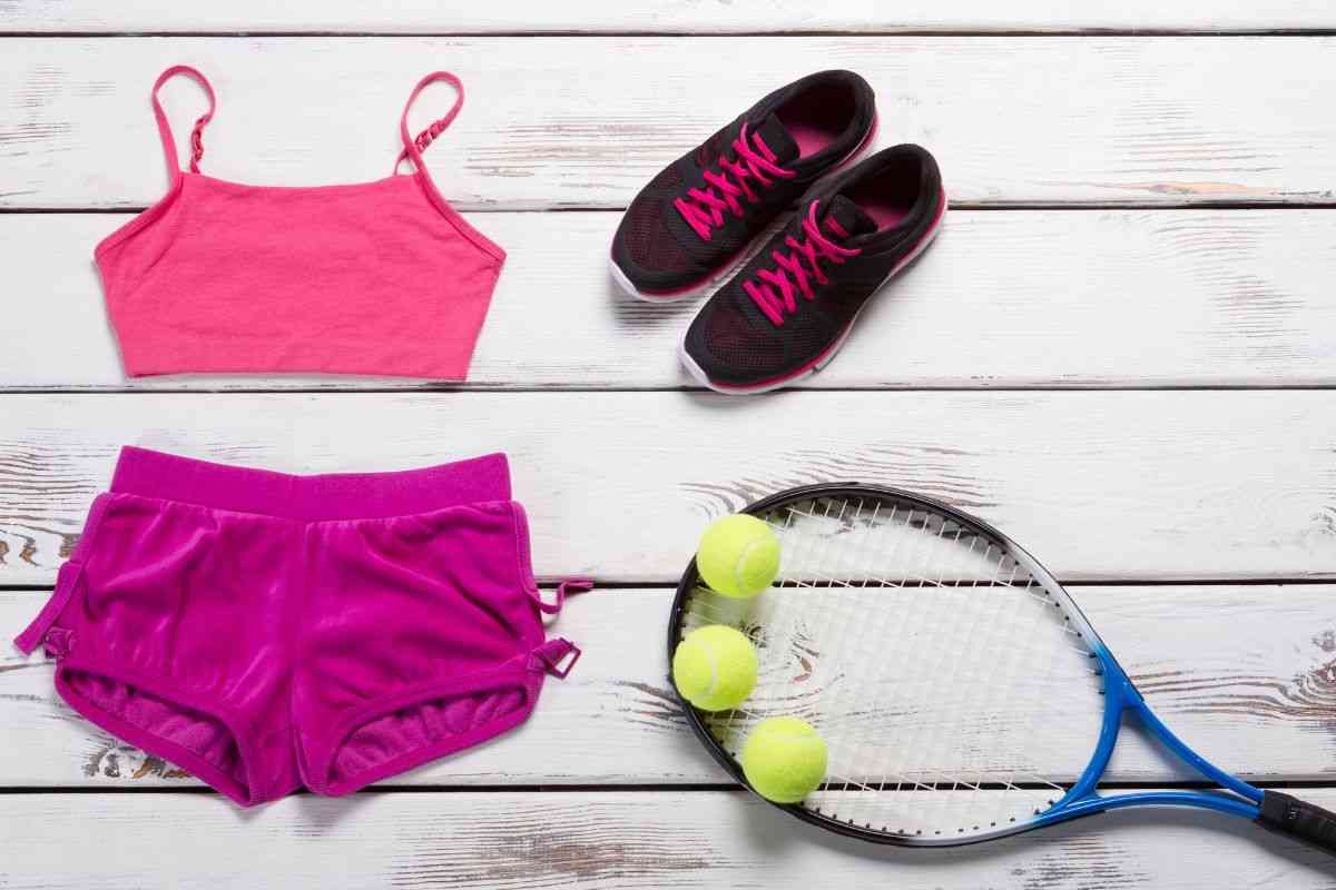 Abbigliamento sporti e racchetta da tennis con palle